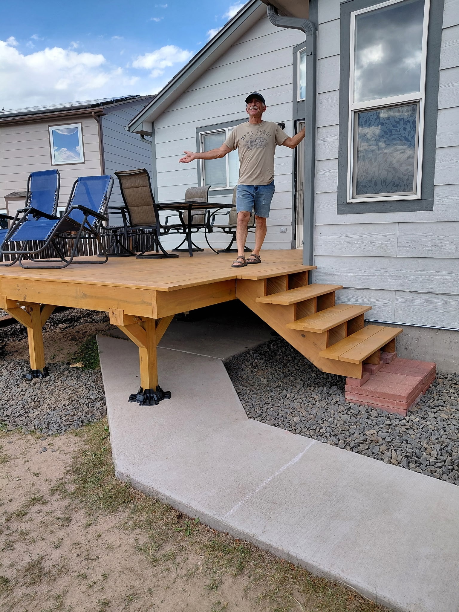 Completed deck with custom stairs and happy homeowner