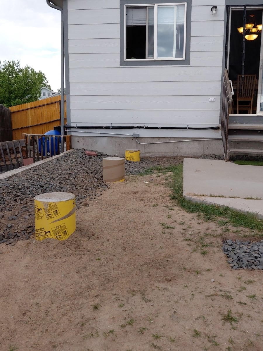 Deck construction in progress with concrete footings poured